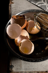 Cracked eggshells and whisk on the table, space for text
