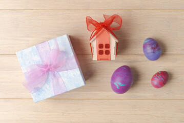 Gift Box and House-Shaped Gift Box with Painted Eggs on Wooden Surface - 741465732