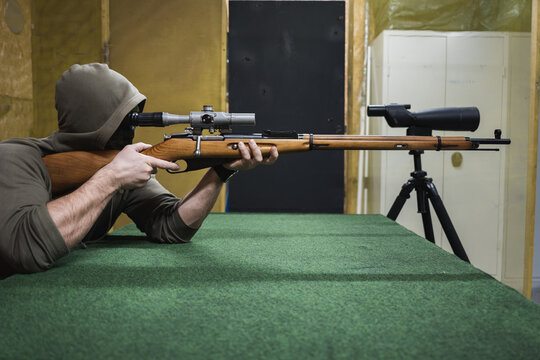 Sniper with old classic bolt action rifle at a shooting range.