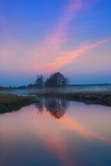 Landscape after sunset with beautiful reflection of the sky and trees in the river - 741465966