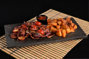 portion of fried Calabrian sausage with onion and roasted potatoes with spices and paprika