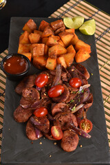portion of fried Calabrian sausage with onion and roasted potatoes with spices and paprika