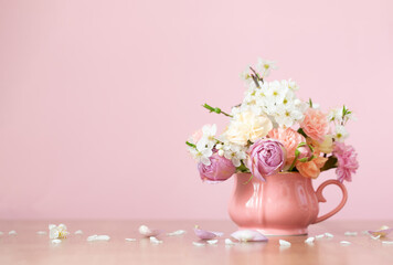 beautiful spring flowers in vintage cup in pastel colors on pink background