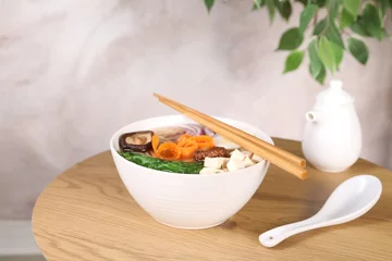  Delicious vegetarian ramen served on wooden table. Noodle soup © New Africa