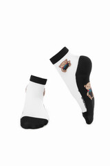 Close-up shot of a pair of transparent mesh socks with embroidered teddy-bears on the bottoms, black toes, black bottoms and black rims. Thin socks are isolated on a white background. Front view.