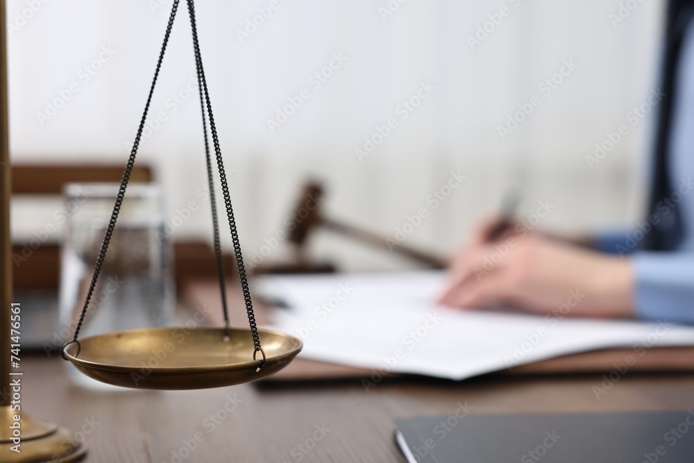 Sticker Lawyer working with documents at wooden table, focus on scales of justice