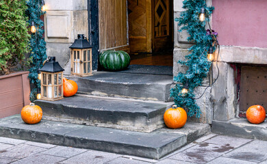 Beautiful decoration of orange and green pumpkins on the porch of a house. - 741477120