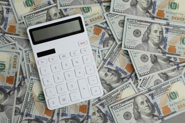 Money exchange. Dollar banknotes and calculator, top view