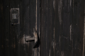 A photograph of an old dark brown wooden door is used as a background wallpaper image.