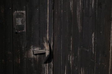 A photograph of an old dark brown wooden door is used as a background wallpaper image.