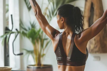 Foto op Plexiglas yoga enthusiast in a leather sports bra stretching in a gym © studioworkstock