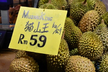 Delicious juicy fleshy aromatic Malaysian durians sold by fruit stalls in night market, Bukit...