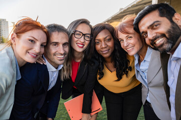 Multiracial group of businesspeople taking a selfie together with coworkers in the office after...