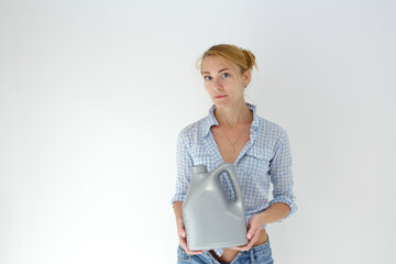 Woman holding canister of motor oil on light background