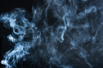 Against the backdrop of darkness, wisps of smoke glide and sway, leaving behind a trail of fleeting elegance.