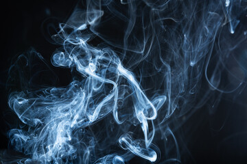 Amidst the blackness, ethereal wisps of smoke ascend, weaving intricate patterns against the void.