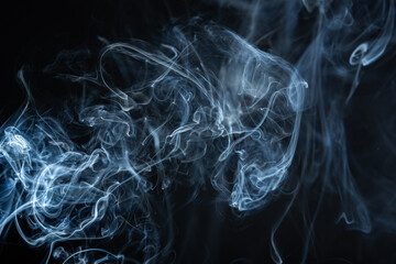 Smoke rising on a dark background, creating interesting shapes