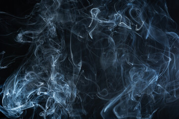 Smoke rising on a dark background, creating interesting shapes