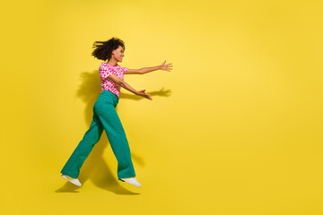 Fototapeta na wymiar Full body profile portrait of crazy energetic lady jump run arms catch empty space isolated on yellow color background