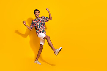 Full body length photo of young yelling man in white shorts and t shirt raised fists up chilling isolated on yellow color background