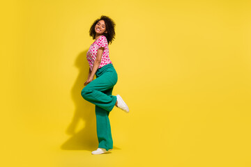 Full body profile portrait of positive nice shy modest lady stand one leg empty space ad isolated on yellow color background © deagreez