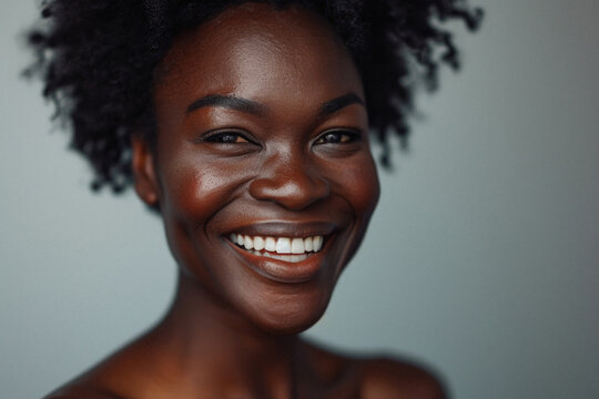 Young adult African American woman posing for beauty portrait. Pretty smiling happy Black girl fashion model smiling on background, attractive ethnic girl looking at camera. Close up face .