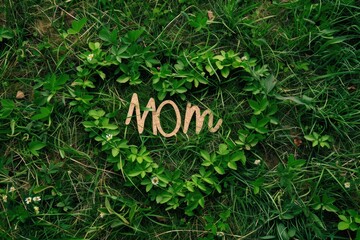 Heart made of leaves with the word mother on the grass, mother's day concept.