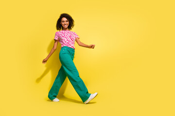 Full size profile portrait of lovely pretty girl walking empty space advert isolated on yellow...