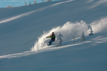 Snowboarding Powder Snow. A snowboarder making a powder turn on a piste covered with fresh snow on a sunny morning