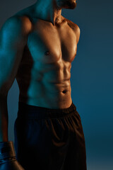 cropped view of young african american man posing topless with black shorts and boxing gloves in gym