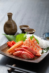 蟹蒲鉾と日本酒、陶器の皿に盛りつけた多種類の蟹蒲鉾