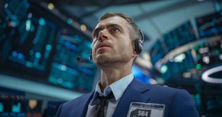 Fototapeta premium Close Up Portrait of a Smart and Thoughtful Stock Exchange Broker. Adult Man in Looking at Computer Screens, Analyzing Stock Exchange Market Data, Brainstorming a Successful Buying Strategy