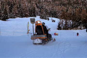 Maintenance workers riding a snowmobile to monitor the ski slope in Val-Cenis, a resort in the French Alps
