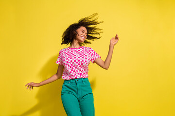 Portrait of carefree cheerful person have good mood dancing empty space isolated on yellow color...
