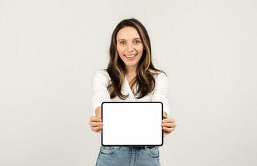 Naklejka premium Excited young woman presenting a blank tablet screen with a white border