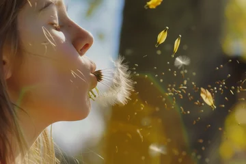 Foto op Plexiglas girl blowing seeds from a dried yellow dandelion head © studioworkstock