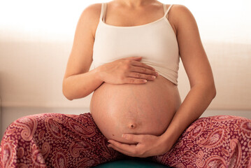Fototapeta na wymiar Mindful Prenatal Moment: Expectant Mother with Hands on Belly