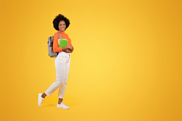 Fototapeta na wymiar Smiling young African American woman with natural hair, wearing a bright orange turtleneck