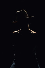 Dark studio portrait of young elegant sexy woman with a white hat and white shirt
