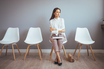 Full length studio shot of an attractive young businesswoman sitting with her hand on her chin...