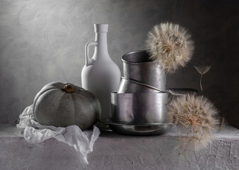 Still life with aluminum dishes, pumpkins and wilted dandelions