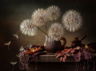 Modern still life with large dandelions in a clay jug on a dark background