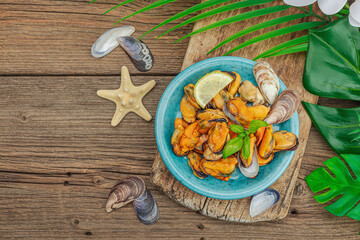 Fototapeta na wymiar Mussels with oil, spices and greens. Healthy seafood is rich in omega. Marine decor