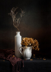 Modern still life with dried hydrangea in a vase on a dark background