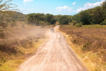 A safari vehicle on a dirt road in the wild at Lake Nakuru National Park in Kenya