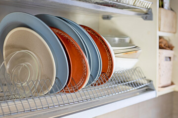 different glass and ceramic plates for food stand in the kitchen cabinet