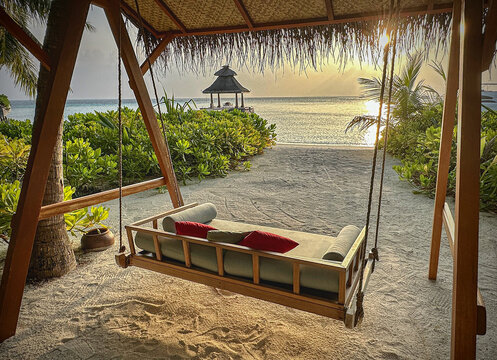 Swing seat on a beach on Baros Island, Maldives looking out to a sunset