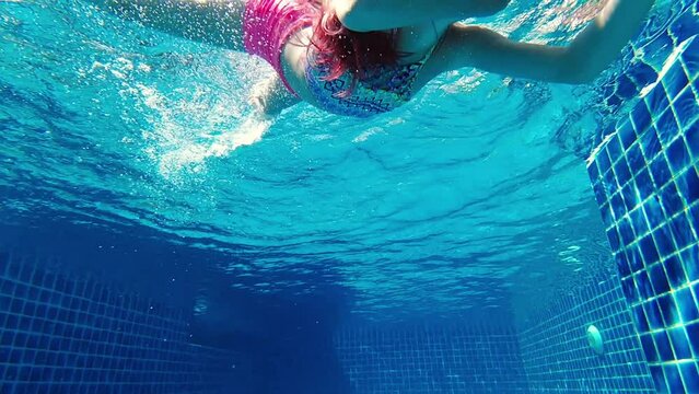 Girl swimming underwater in the pool