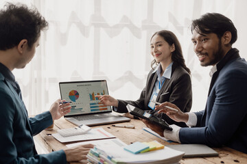 Meeting of young Asian businessmen by laptop, planning and teamwork in meeting to get information, charts and strategies. Managing projects, budgets, and reporting with office staff.