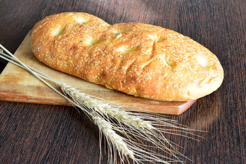 loaf of bread on the cutting board with wheat ears 